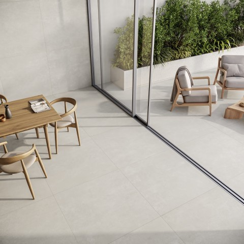 Visão aérea de uma área residencial integrada. O piso de porcelanatos grandes formatos em tom bege claro conecta a sala de jantar interna, com mesa e cadeiras de madeira, à varanda externa que possui poltronas e um jardim ao fundo.
Visão aérea de uma área residencial integrada. O piso de porcelanatos grandes formatos em tom bege claro conecta a sala de jantar interna, com mesa e cadeiras de madeira, à varanda externa que possui poltronas e um jardim ao fundo.