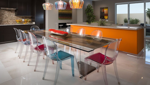 Ambiente de jantar com cozinha integrada e bancada laranja, com mesa de vidro e cadeiras de plástico que adicionam um toque de modernidade e leveza. Ambiente de jantar com cozinha integrada e bancada laranja, com mesa de vidro e cadeiras de plástico que adicionam um toque de modernidade e leveza.