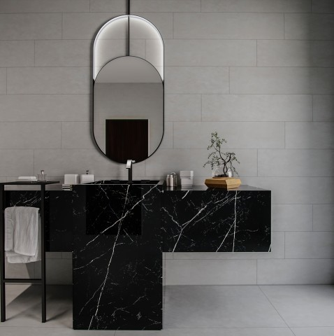 Banheiro sofisticado com revestimento de porcelanato cimento queimado cinza em réguas horizontais na parede e placas grandes no piso. No centro, destaca-se uma bancada suspensa com cuba esculpida em mármore preto com veios brancos. Acima da bancada, há um espelho oval alongado com iluminação LED embutida e moldura preta, além de uma pequena planta bonsai e acessórios de higiene dispostos sobre o balcão. Banheiro sofisticado com revestimento de porcelanato cimento queimado cinza em réguas horizontais na parede e placas grandes no piso. No centro, destaca-se uma bancada suspensa com cuba esculpida em mármore preto com veios brancos. Acima da bancada, há um espelho oval alongado com iluminação LED embutida e moldura preta, além de uma pequena planta bonsai e acessórios de higiene dispostos sobre o balcão.